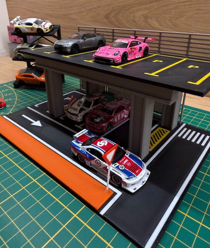 A multi-level miniature parking garage with toy cars, displaying detailed 3D prints