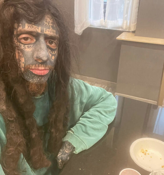 Florida Demonologist showing full face tattoos and long hair sitting at a table Florida Demonologist showing full face tattoos and long hair sitting at a table