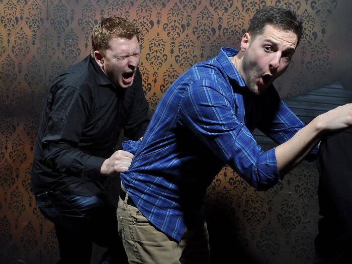 Haunted house photo capturing two men terrified and grabbing each other