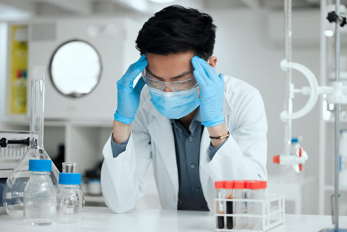 A stressed scientist in a lab coat, highlighting people share breaking point moments.