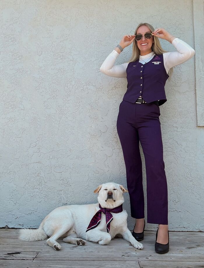 A woman and her dog wearing matching flight attendant uniforms showing how pets look like their owners.
