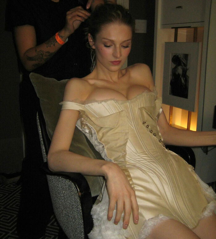 Trans actress in vintage corset getting ready in backstage room