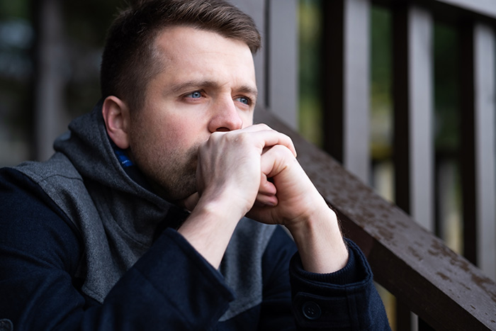 Thoughtful husband looking away, sensing something is off after his wife’s girls’ trip.