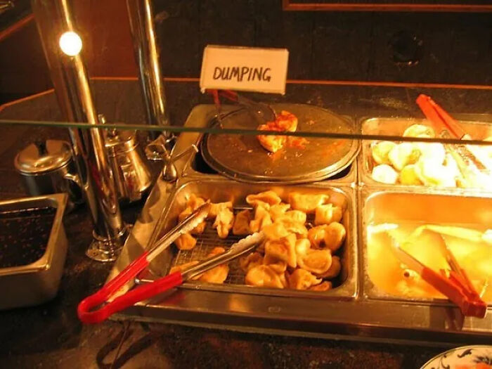 Buffet food station with a translation fail labeling dumplings as dumping.