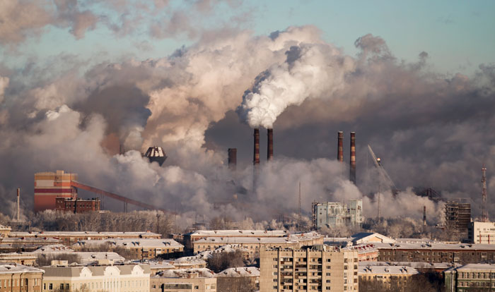 Factory smokestacks emitting pollution illustrating environment threats to health and survival