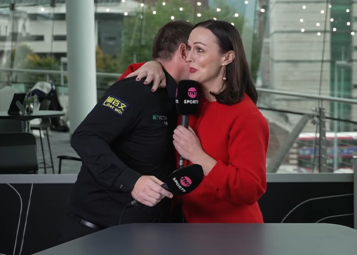 Reporter Rachel Casey hugging Mark Allen in a supportive response following his emotional interview.