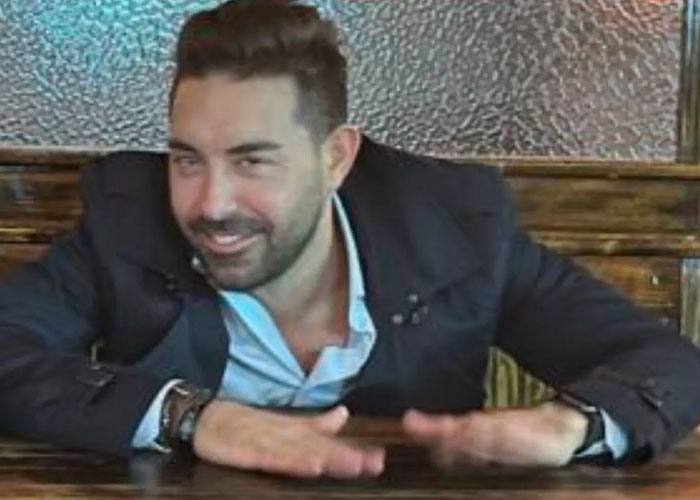 A man sitting at a table in a case where an Amazon Exec Accused of misconduct
