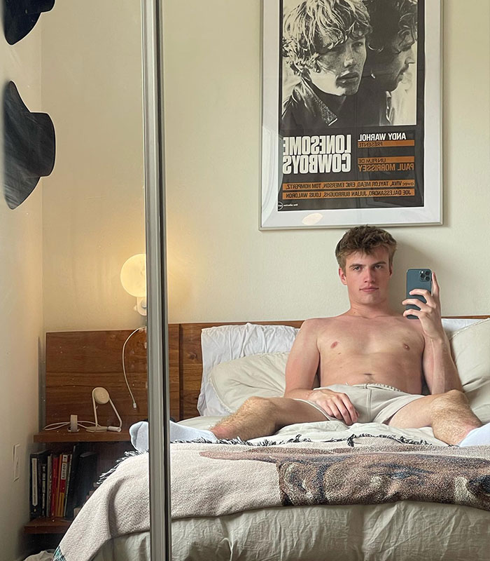 Adult content creator Nick taking a mirror selfie in bed, linked to the Hollywood star cheating controversy.