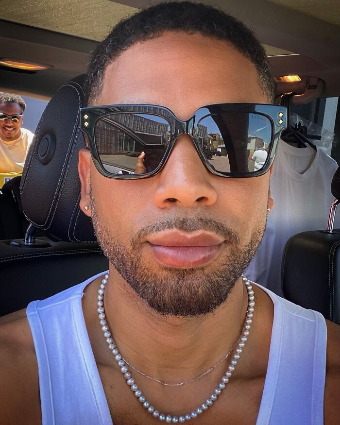 Actor Jussie Smollett wearing sunglasses in a car, one of the stars who got in the way of their own success.