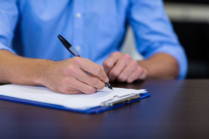 Close-up of a person filling out legal documents tied to real-life divorce stories