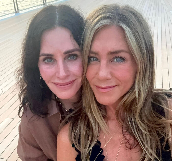 Friends co-stars Courteney C*x and Jennifer Aniston posing together for a close selfie outdoors.