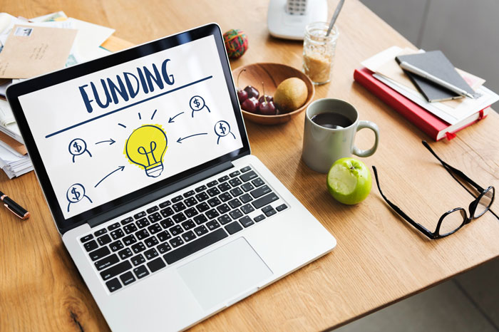 Laptop displaying funding graphics related to a middle school honest fundraiser concept.