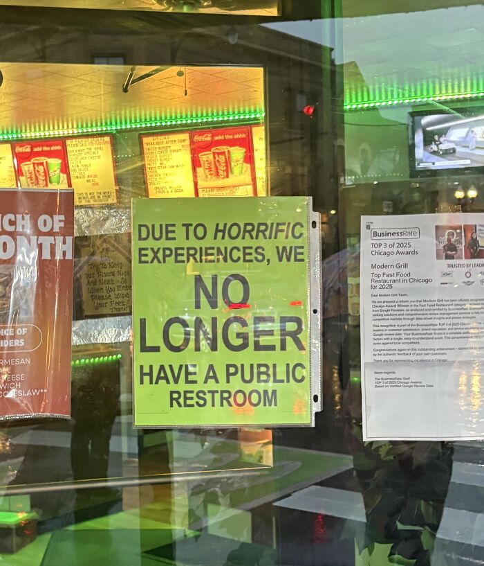 Absurd signs in a restaurant window stating no public restroom due to horrific experiences.