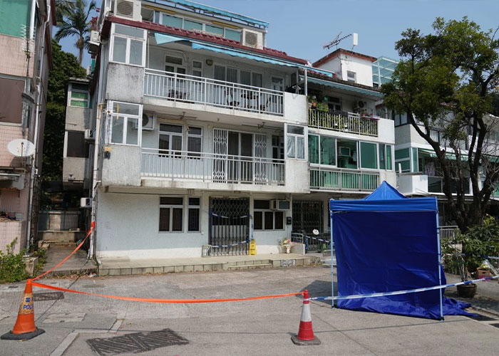 Residential building with blue tent and police cordon outside Residential building with blue tent and police cordon outside