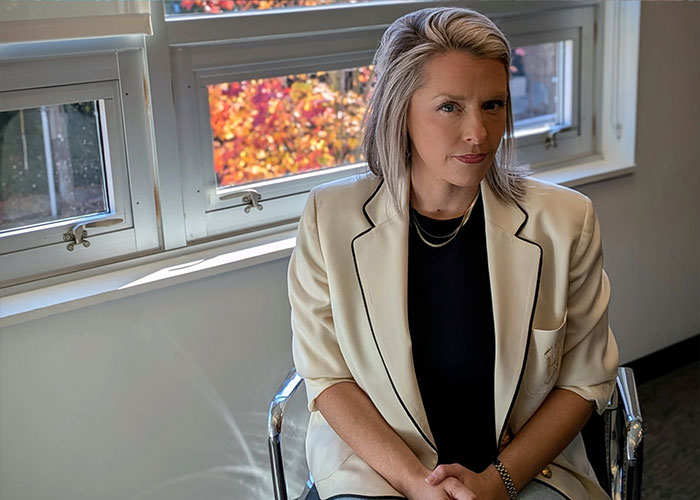 Female employee involved in the Amazon Exec Accused case posing near a window