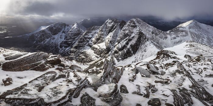 Dramatic snow-covered mountain range under moody skies, shown in Natural Landscape Photography Awards 2026.