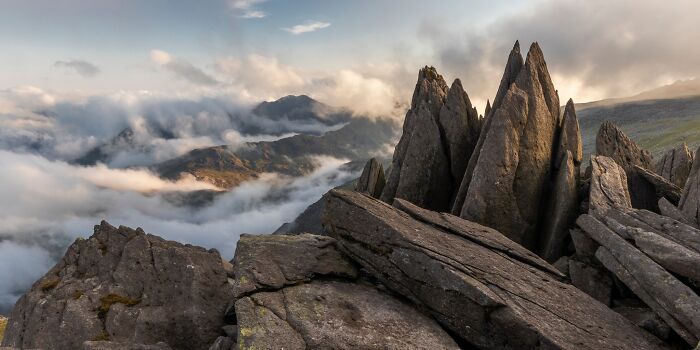 Jagged rock formations emerging from sea of clouds in Natural Landscape Photography Awards 2026.