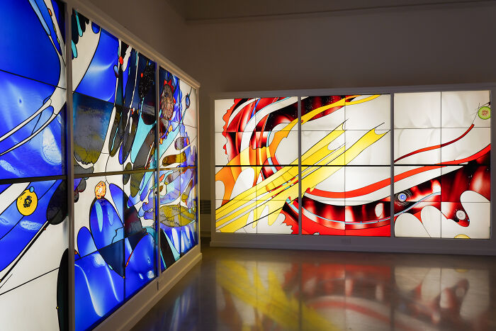 Modern abstract stained glass artworks illuminated on wall panels Modern abstract stained glass artworks illuminated on wall panels