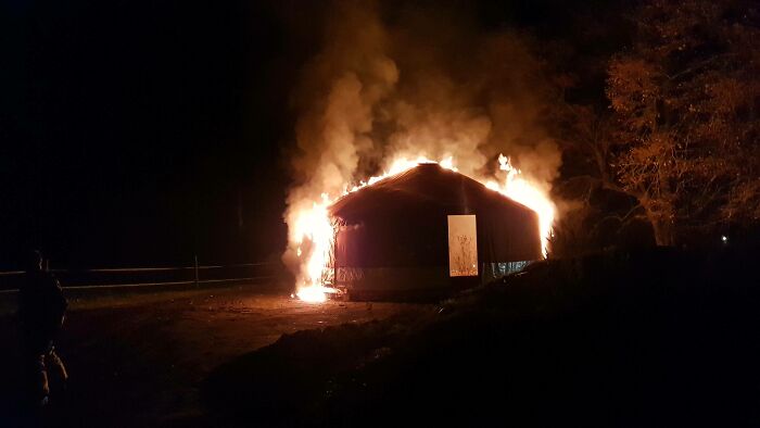 A yurt completely engulfed in flames at night, a devastating home renovate disaster