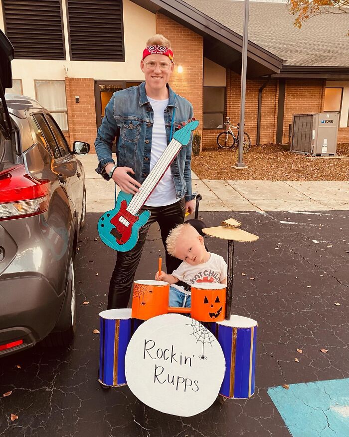 A dad and young boy with a drum set costume for people with disabilities celebrating Halloween outdoors.