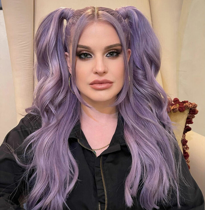 Kelly Osbourne with purple pigtails hairstyle, featured in an article about her weight gain and plastic surgery.