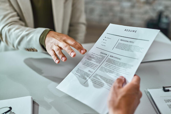 A person reviewing a printed resume during an interview, related to obvious lies on a job application.