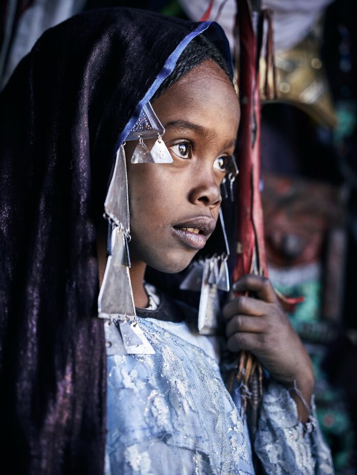 A young girl in traditional dress looking off camera, showing the beauty of human expression in portrait photos.