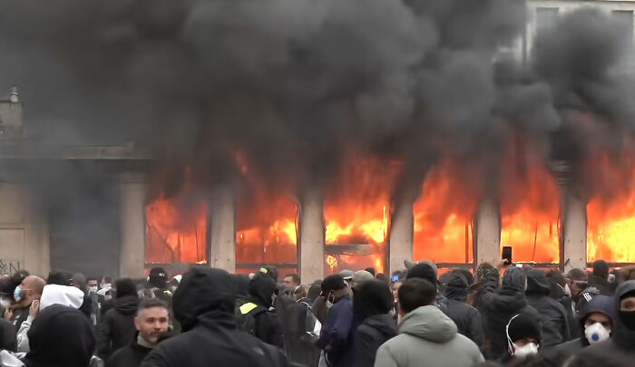 Building engulfed in flames with smoke during France riots protest