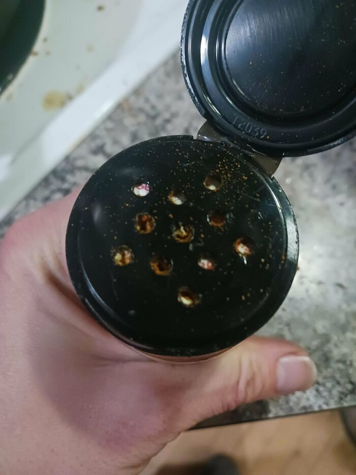 A spice shaker with the inner paper seal not fully removed, representing husband's funniest quirks