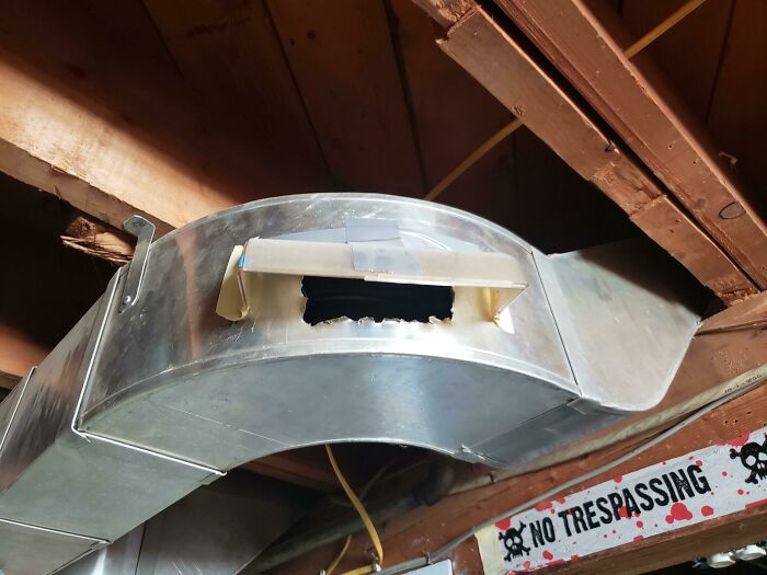 A makeshift DIY project with duct tape patching a hole in a metal air duct.