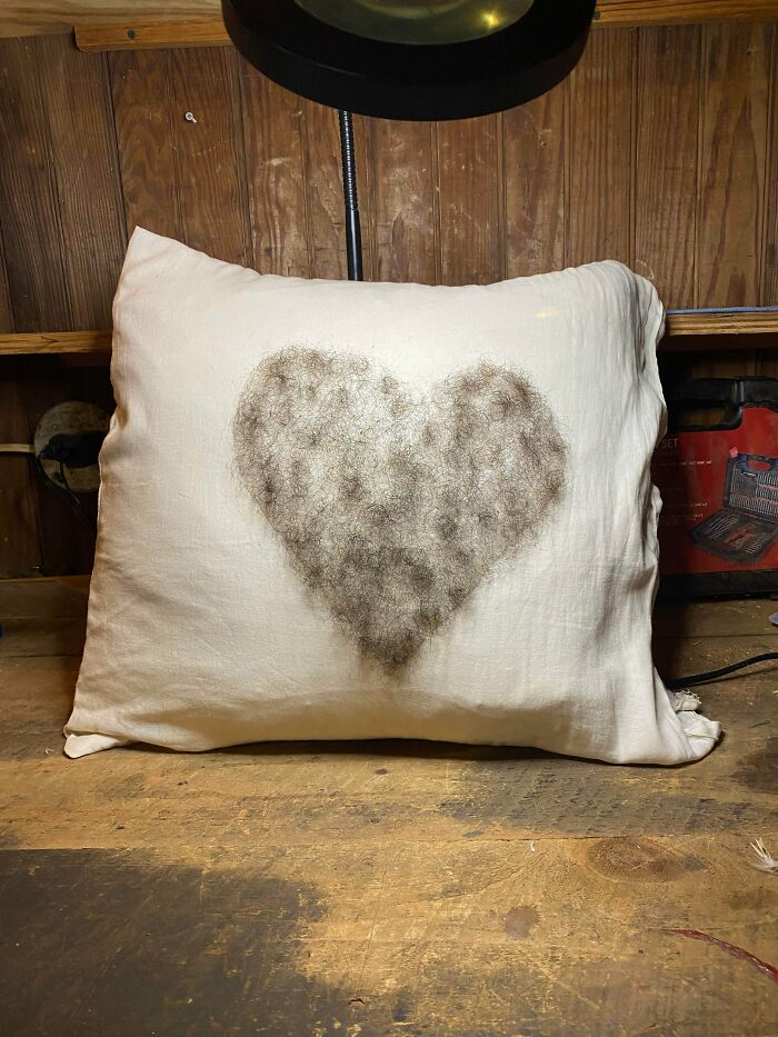 An unusual DIY project featuring a white pillow with a heart shape filled with fuzzy hair.