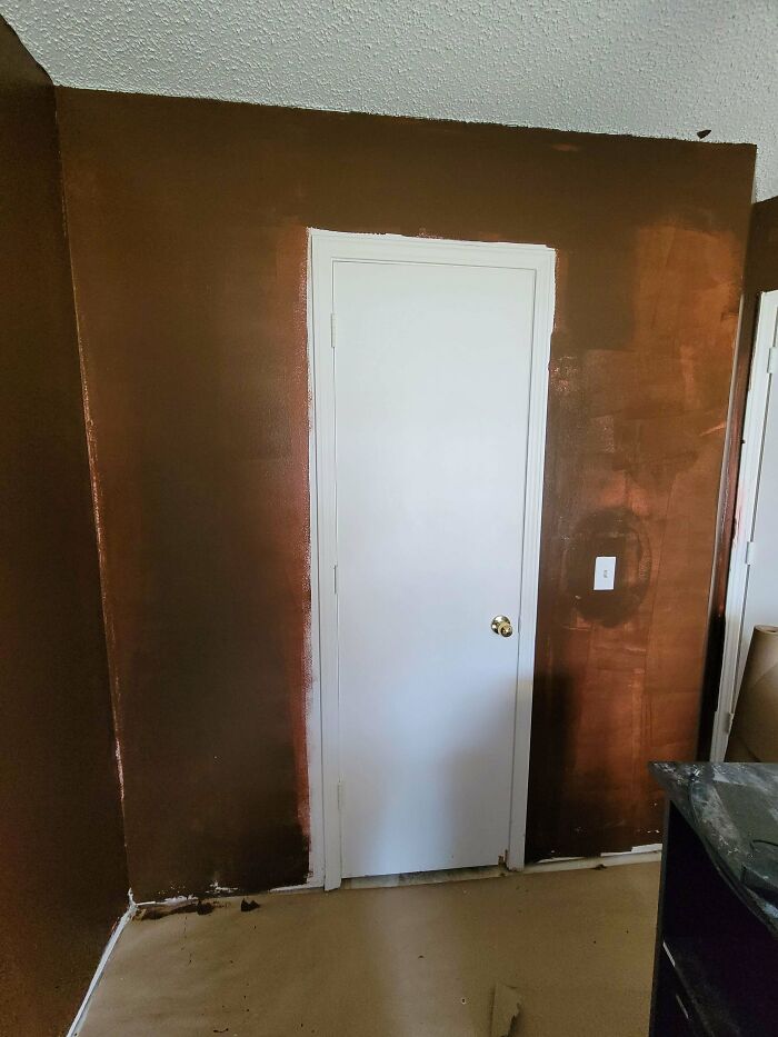 A poorly painted wall next to a white door showing the results of a rushed DIY project.