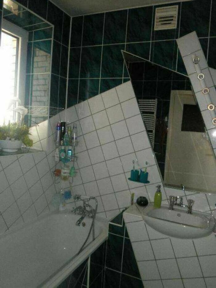Quirky bathroom DIY projects with white tiles and a mirror placed at an unusual diagonal angle