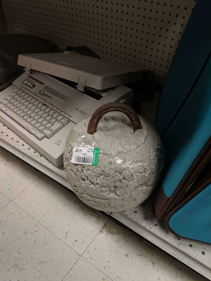 A round concrete weight with a metal handle as a rustic DIY project sitting on a shelf