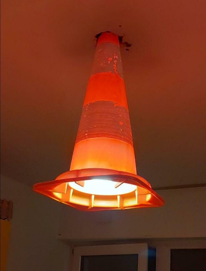 An orange traffic cone repurposed as a ceiling light fixture in creative DIY projects