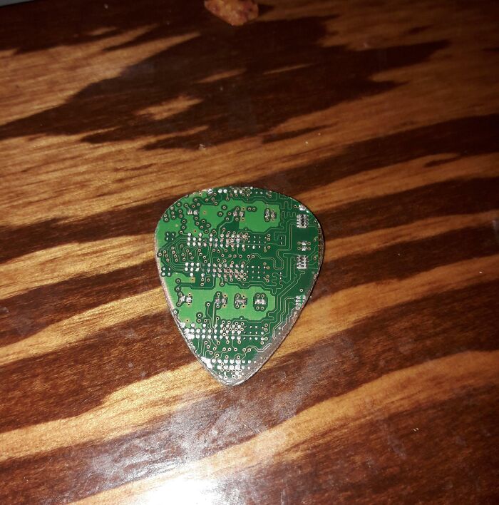 A guitar pick crafted from a green computer circuit board as one of the DIY projects