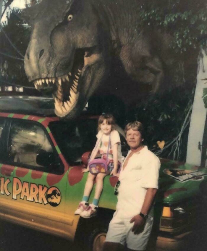 A family posing in front of a T-Rex bringing back 90s childhood memories