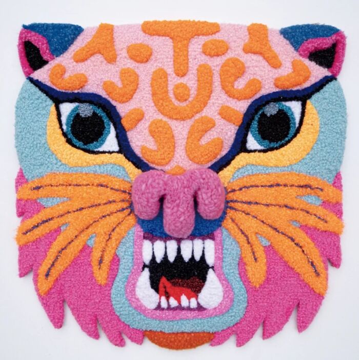 Vibrant tufted tiger face rug with teeth and whiskers by Ina Dyreborg