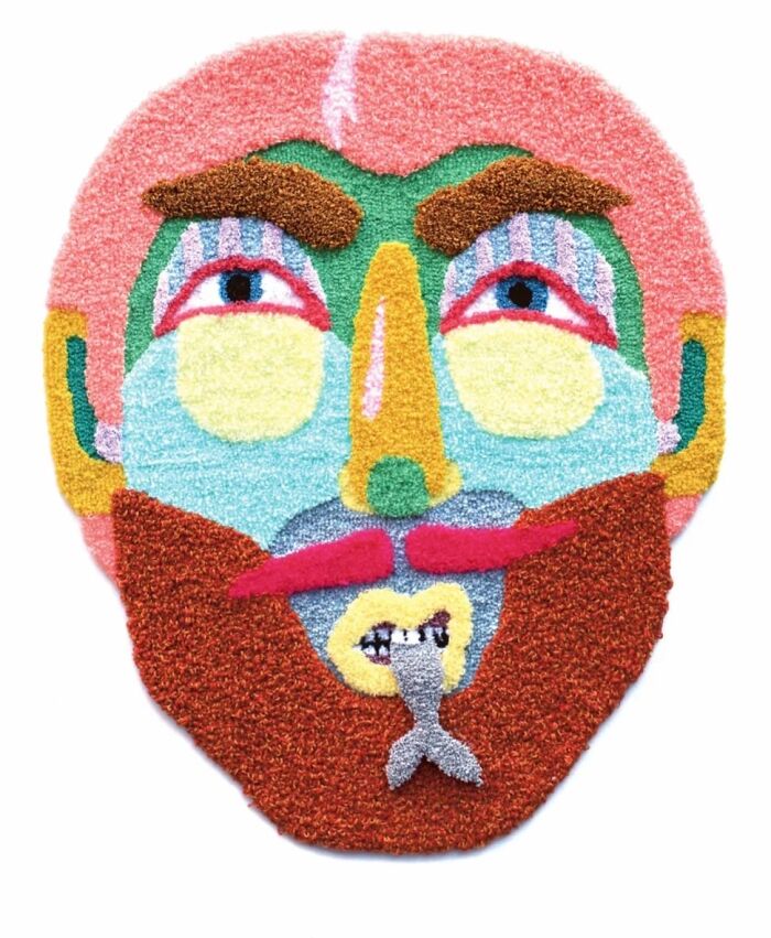 Colorful tufted face mask textile art featuring a bearded man by Ina Dyreborg