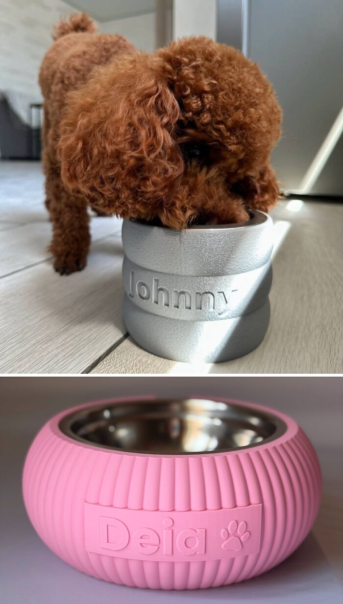 A small brown dog eating from a silver personalized 3D printed bowl and a pink 3D printed bowl below it.