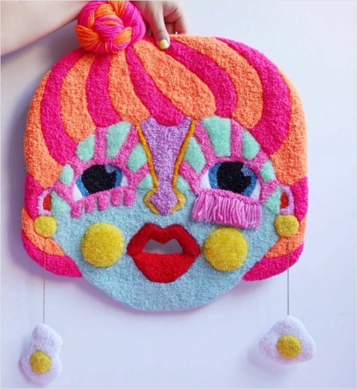 Colorful doll face tufted rug with fried egg earrings created by Ina Dyreborg.