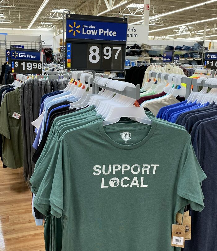 A rack of green Support Local t-shirts highlighting aspects of modern life in America.
