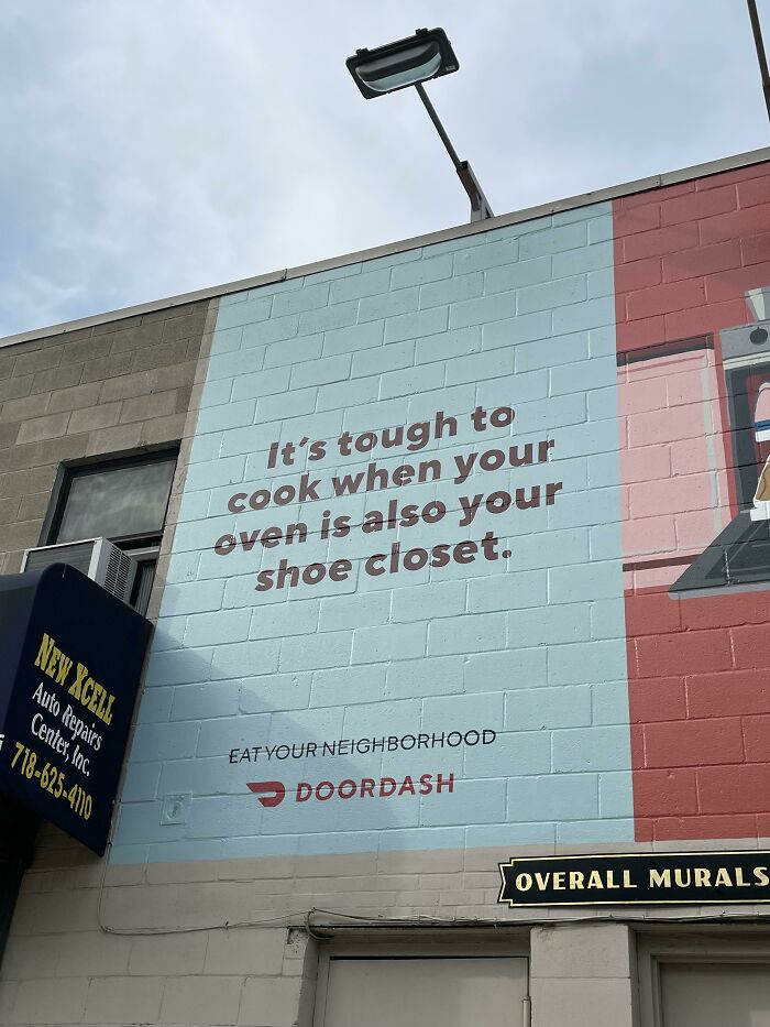 DoorDash advertisement mural on a brick wall illustrating modern life in America.