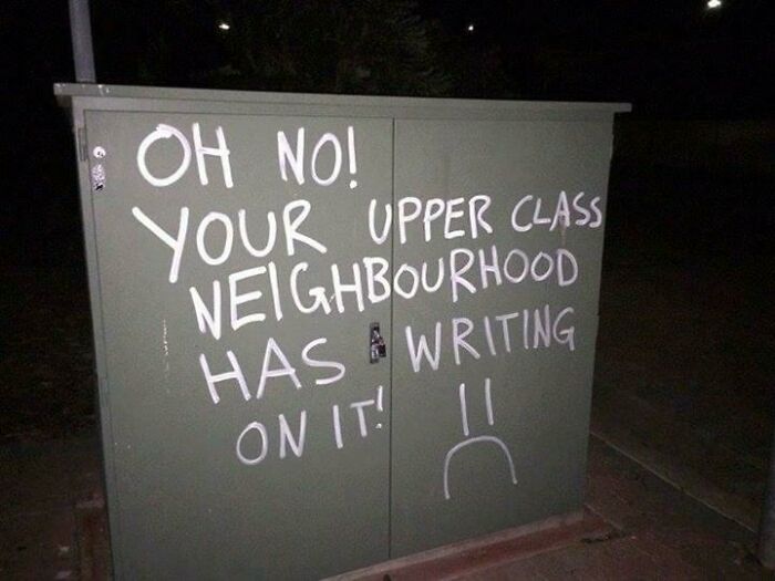 Vandalism showing a humorous message on a green utility box about an upper class neighbourhood.