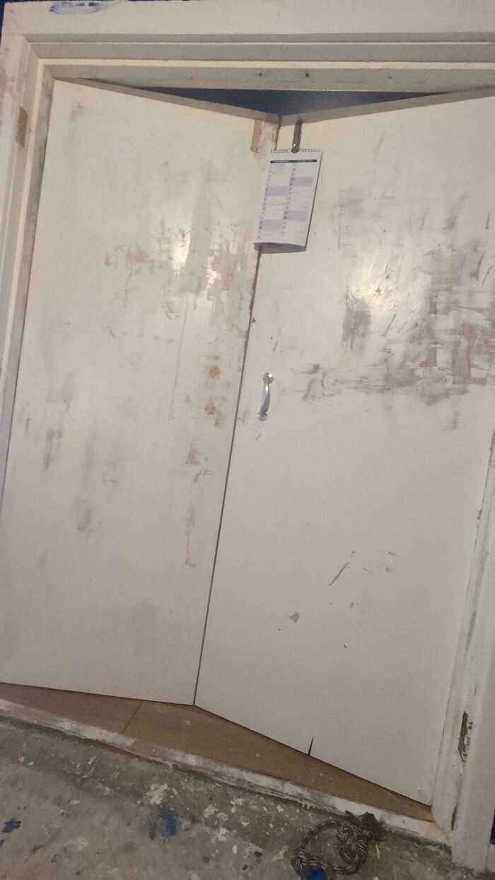 Messy paint streaks and a makeshift calendar on bi-fold closet doors, showcasing a poor home improvement effort
