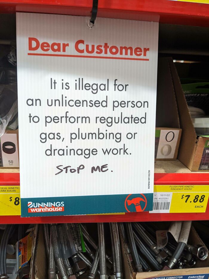 A hardware store warning sign with a defiant handwritten graffiti note, showing an act of vandalism as public art.