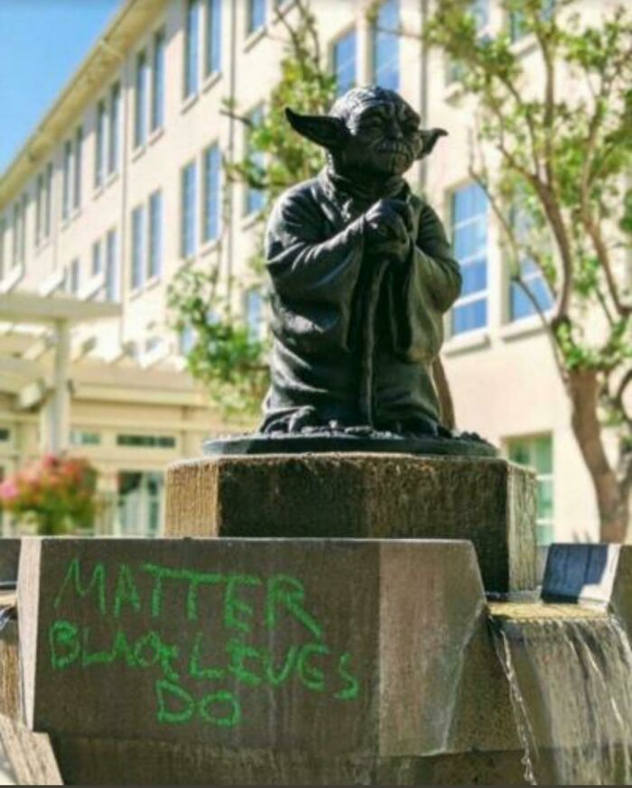 Yoda statue with green graffiti reading Matter Black Lives Do, representing creative acts of vandalism.