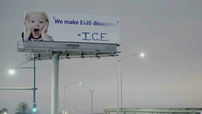 An altered billboard with political graffiti about ICE, showcasing clever vandalism on public signs.