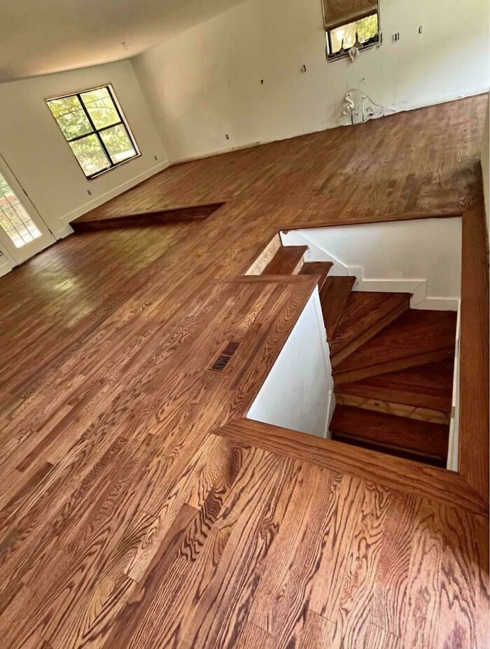 Polished wood flooring with a dangerous open staircase showing poor home renovation.