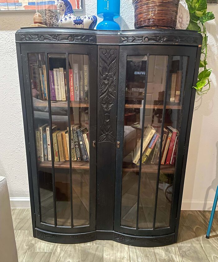 An elegant, vintage dark wood display cabinet with glass doors, a jewel among thrift store finds